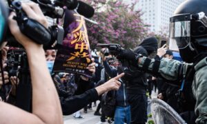 Facing the Barrel of a Gun, Woman Holds Epoch Times Poster to Protest Hong Kong Police