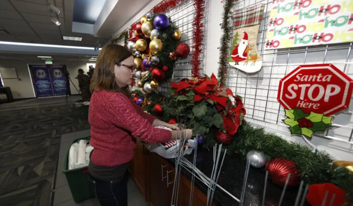 Volunteer Nicole Schreiner places a display of poinsettias in the NORAD Tracks Santa Center at Peterson Air Force Base, in Colorado Springs, Colo.,on Dec. 23, 2019.(David Zalubowski/AP)