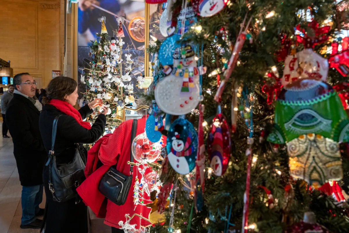 People look at a holiday display as the Christmas holiday approaches in New York City, on Dec. 23, 2019. (David Dee Delgado/Getty Images)