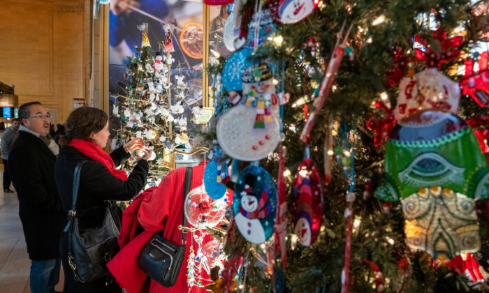 People look at a holiday display as the Christmas holiday approaches in New York City on Dec. 23, 2019. (David Dee Delgado/Getty Images)