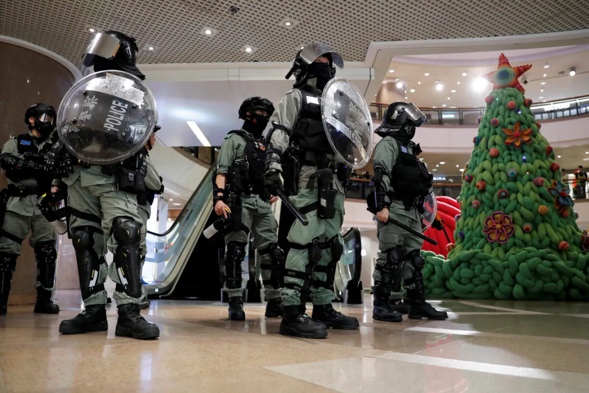 Riot police stand guard next to a Christmas tree inside a shopping mall during a pro-democracy protest on Christmas Eve at Tsim Sha Tsui in Hong Kong, China on Dec. 24, 2019. (Tyrone Siu/Reuters)