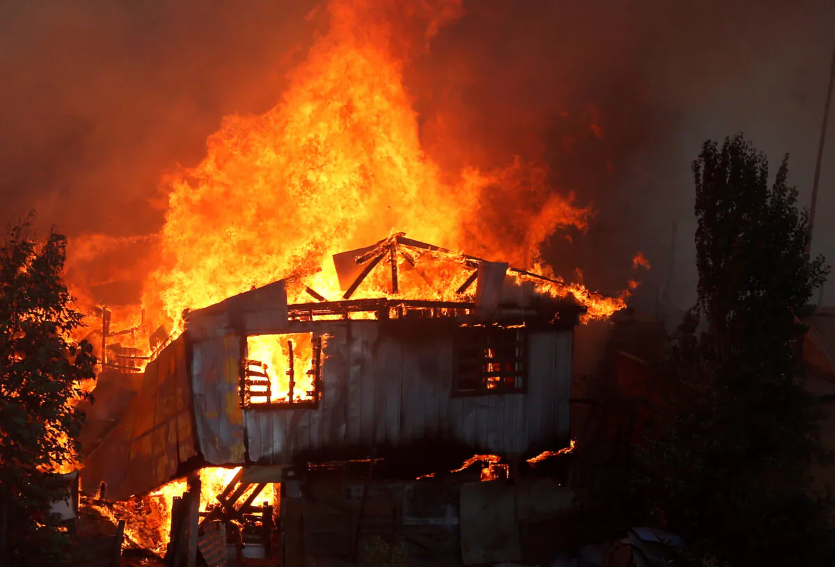 A house burns following the spread of wildfires in Valparaiso, Chile, Dec. 24, 2019. (Reuters/Rodrigo Garrido)