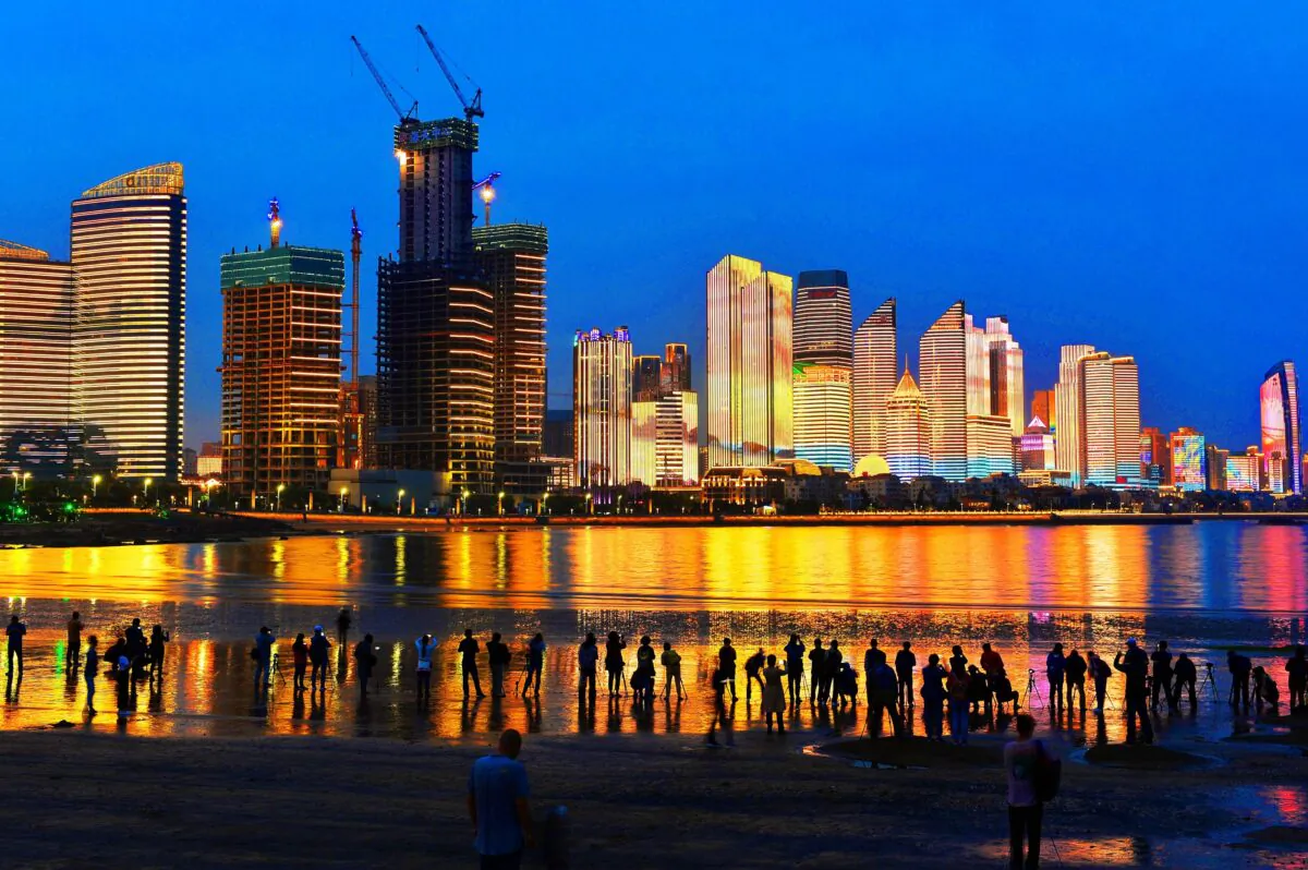 Residents and visitors look at illuminated buildings in Qingdao in China's eastern Shandong Province on May 26, 2018. (AFP via Getty Images)