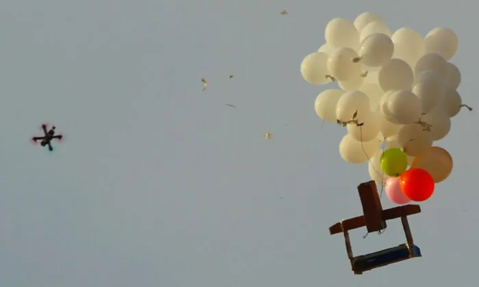 An Israeli army drone approaching balloons  on the Israeli side of the border with the northeast of the Gaza Strip carrying an alleged incendiary device launched by Palestinian protesters in Nahal Oz on Oct. 19, 2018. (Jack Guez/AFP via Getty Images)