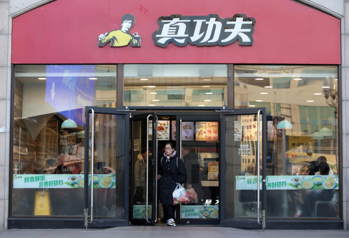 A woman walks out of a restaurant of  Chinese fast food chain Real Kungfu at Beijing Railway Station in Beijing, China on Dec. 27, 2019. (Jason Lee/Reuters)