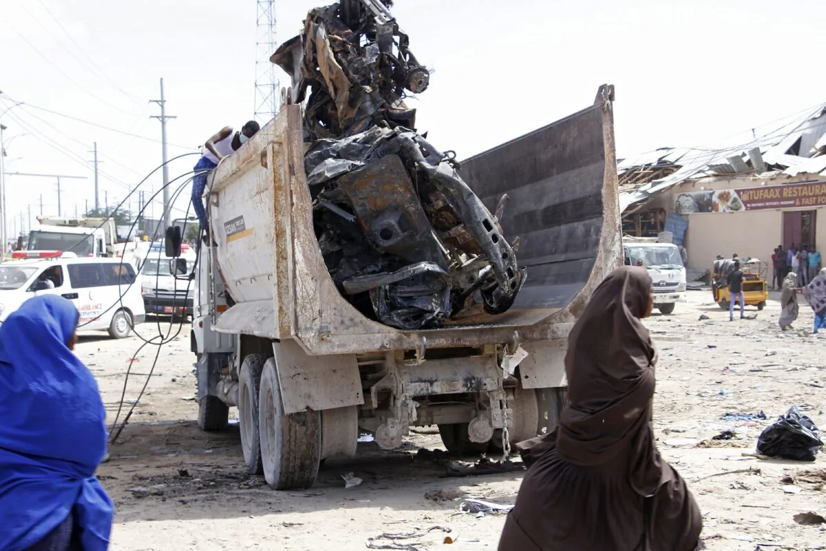 Somali security assess the scene of a car bomb explosion at a checkpoint in Mogadishu, Somalia on Dec. 28, 2019. (Feisal Omar/Reuters)