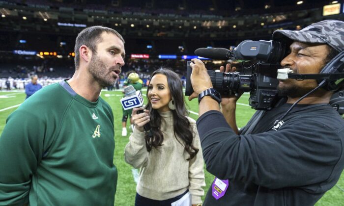 Acadiana head coach Matt McCullough (L) speaks with Carley McCord (C) following a win over the Destrehan in the State Division 5A Championship football game in Lafayette, La., on Dec. 14, 2019. (Scott Clause/The Daily Advertiser via AP)