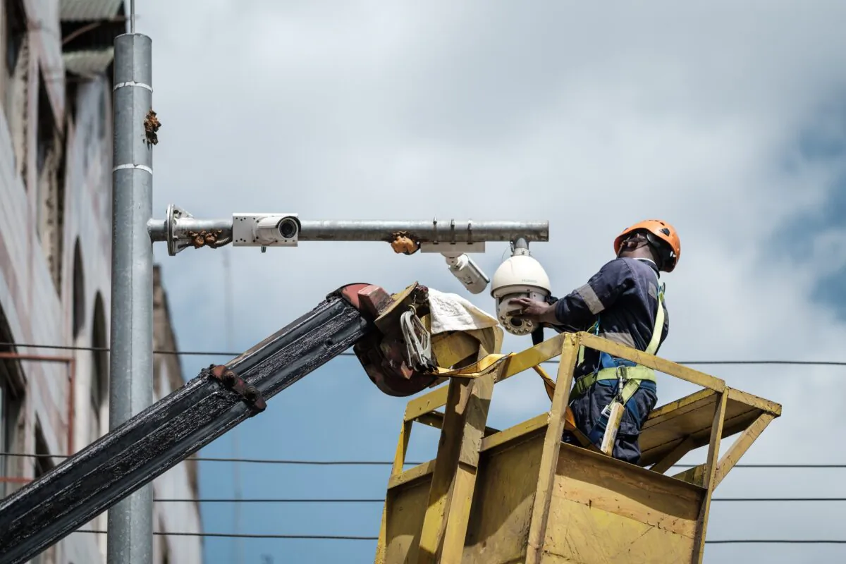 A worker cleans a surveillance camera on a street in Nairobi, Kenya, on Jan. 18, 2019. (YASUYOSHI CHIBA/AFP via Getty Images)