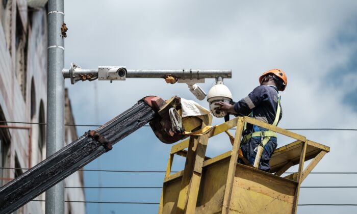 A worker cleans a surveillance camera on a street in Nairobi, Kenya, on Jan. 18, 2019. (YASUYOSHI CHIBA/AFP via Getty Images)