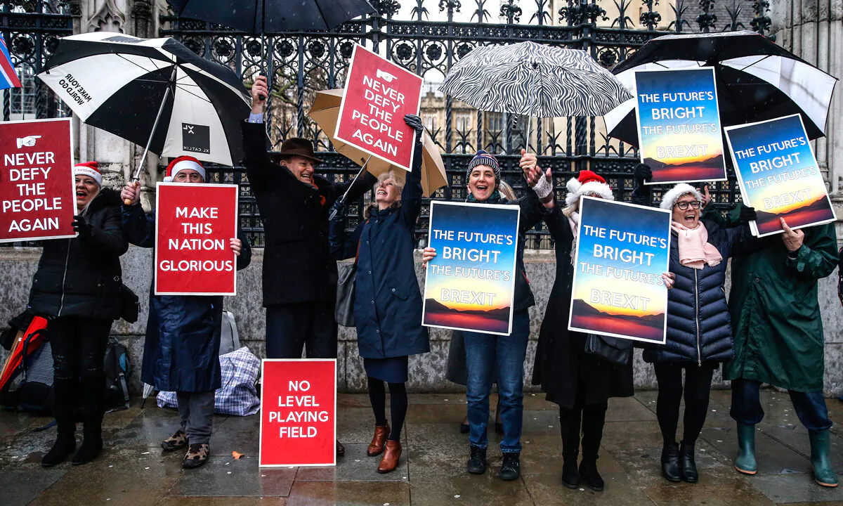 Pro-Brexit campaigners celebrate while hold placards near the Houses of Parliament in London on Dec. 20, 2019. (Hollie Adams/Getty Images)