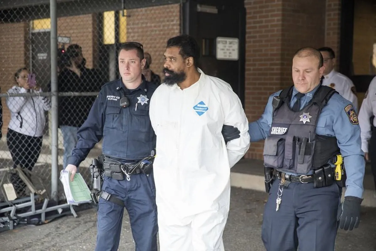 Ramapo police officers escort Grafton Thomas from Ramapo Town Hall to a police vehicle in Ramapo, New York, on Dec. 29, 2019. (AP Photo/Julius Constantine Motal)
