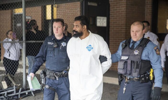 Ramapo police officers escort Grafton Thomas from Ramapo Town Hall to a police vehicle in Ramapo, New York, on Dec. 29, 2019. Thomas is accused of stabbing multiple people as they gathered to celebrate Hanukkah at a rabbi's home in the Orthodox Jewish community north of New York City. (AP Photo/Julius Constantine Motal)
