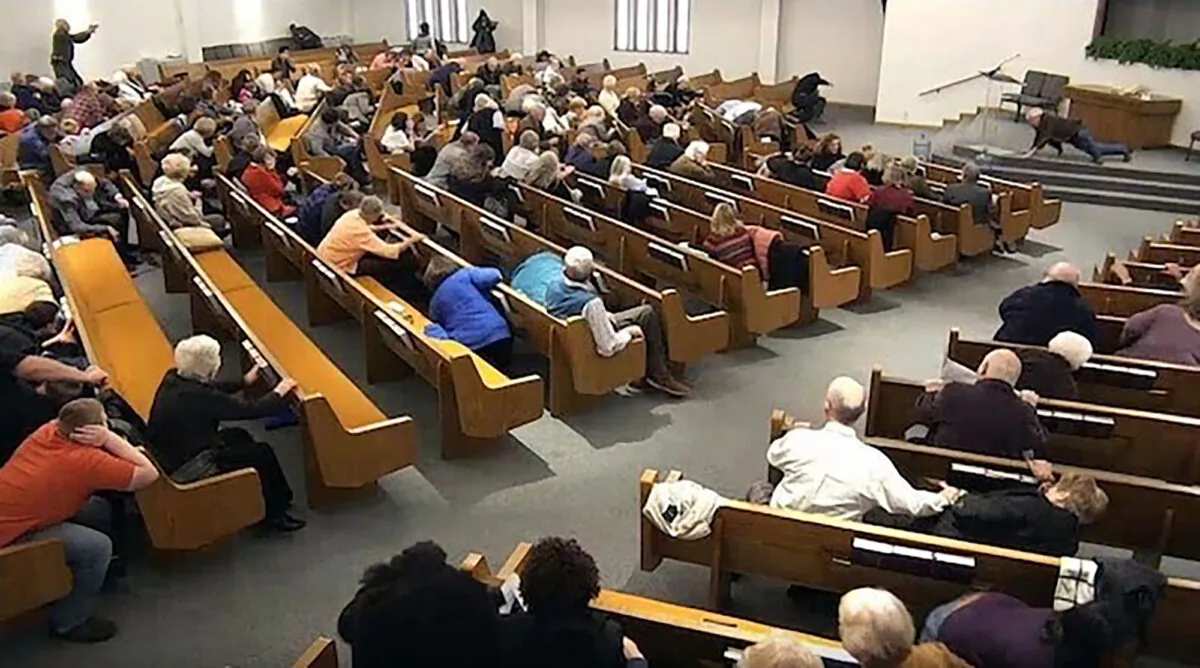 Churchgoers take cover while a congregant armed with a handgun, top left, engages a man who opened fire, near top center just right of windows, during a service at West Freeway Church of Christ in White Settlement, Texas, on Dec. 29, 2019. (West Freeway Church of Christ/Courtesy of Law Enforcement via AP)