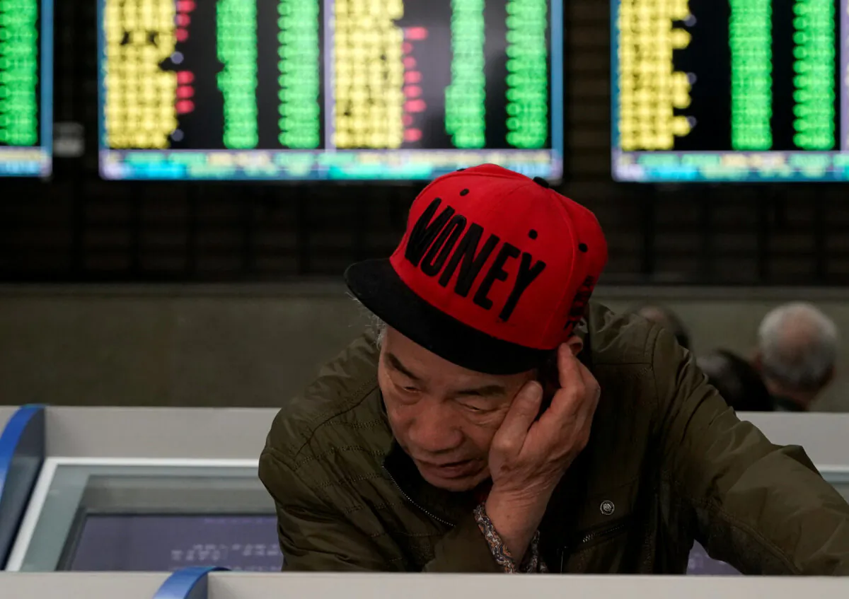 An investor looks at computer screens showing stock information at a brokerage house in Shanghai, China on May 6, 2019. (Aly Song/Reuters)