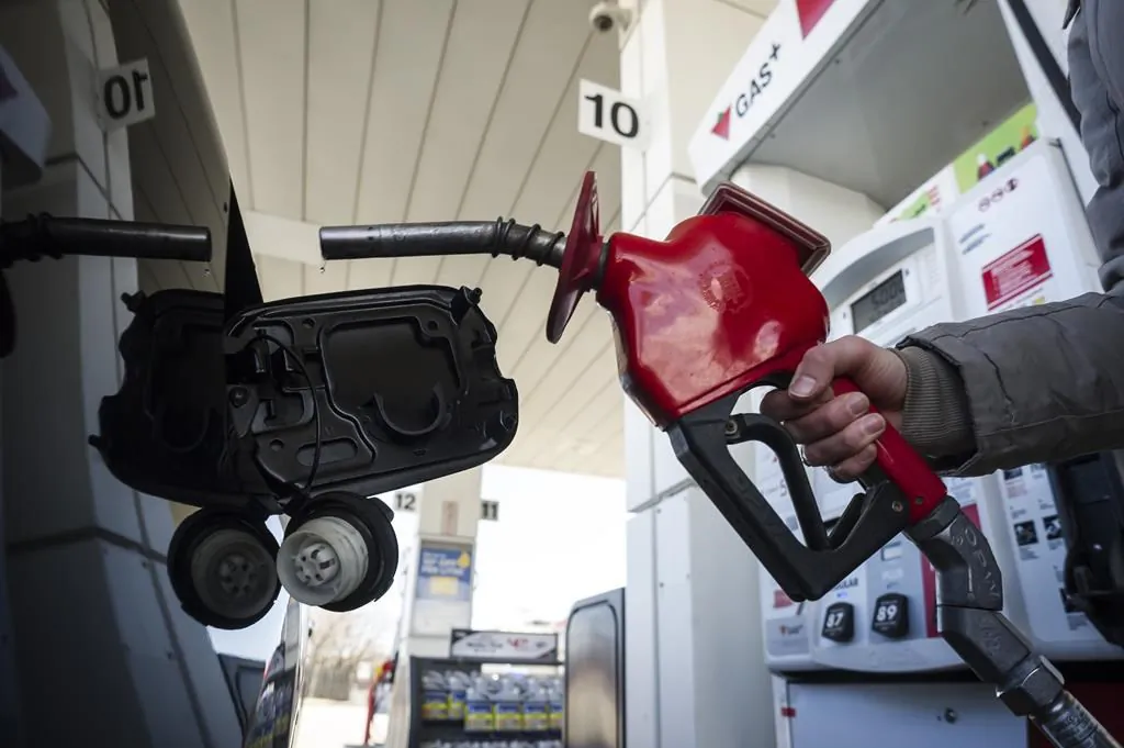 A woman fills up her car with gas in Toronto on April 1, 2019. (The Canadian Press/Christopher Katsarov)