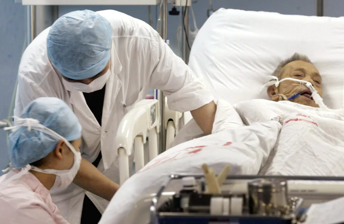 Nurses treat a patient for an unknown ailment in the intensive care unit of the No1 Hospital in Guangzhou, China on June 12, 2003. (Peter Parks/AFP/GettyImages)