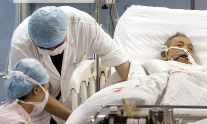Nurses treat a patient for an unknown ailment in the intensive care unit of the No1 Hospital in Guangzhou, China on June 12, 2003. (Peter Parks/AFP/GettyImages)