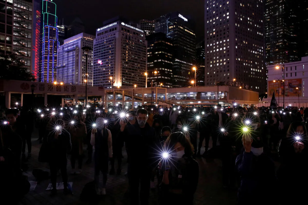 Pro-democracy protesters use the flashlights of their mobile phones as they take part in a protest in Edinburgh Place in Hong Kong, China on Dec. 30, 2019. (Navesh Chitrakar/Reuters)