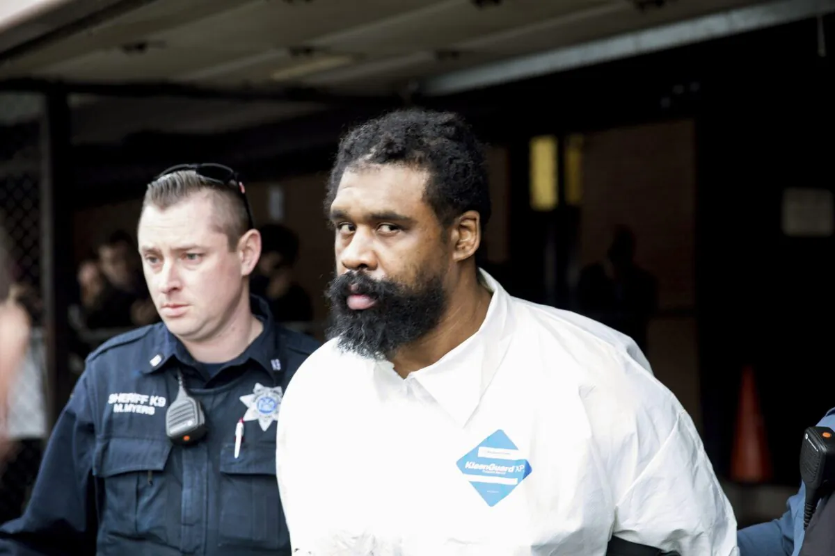 Ramapo police officers escort Grafton Thomas from Ramapo Town Hall to a police vehicle in Ramapo, New York, on Dec. 29, 2019. (Julius Constantine Motal/AP Photo)