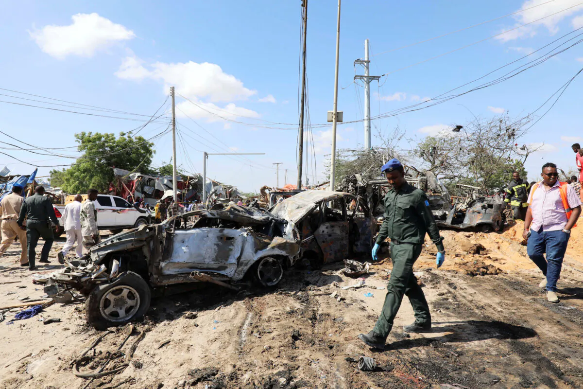A Somali police officer walks past a wreckage at the scene of a car bomb explosion at a checkpoint in Mogadishu, Somalia, on Dec. 28, 2019. (Reuters/Feisal Omar)