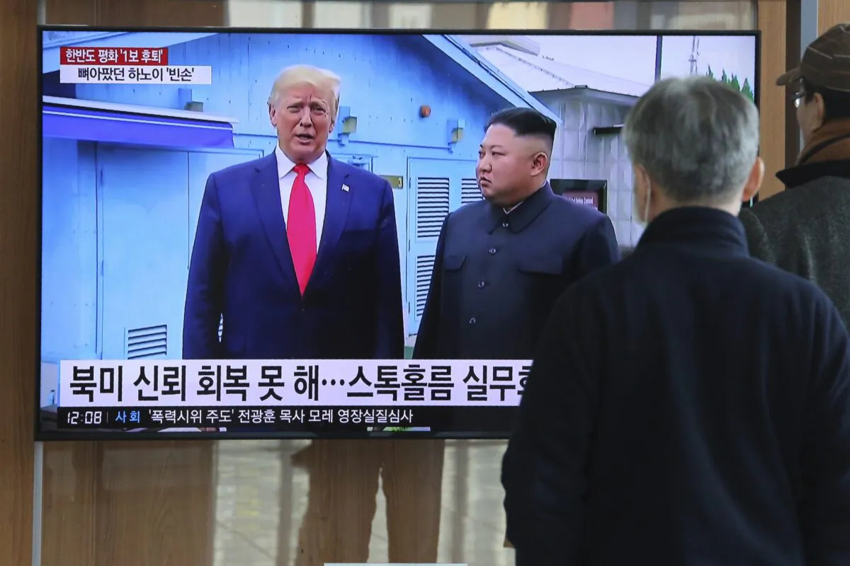 People watch a TV screen showing a file image of North Korean leader Kim Jong Un and U.S. President Donald Trump (L) during a news program at Seoul Railway Station in Seoul, South Korea, on Dec. 31, 2019. (Ahn Young-joon/AP Photo)