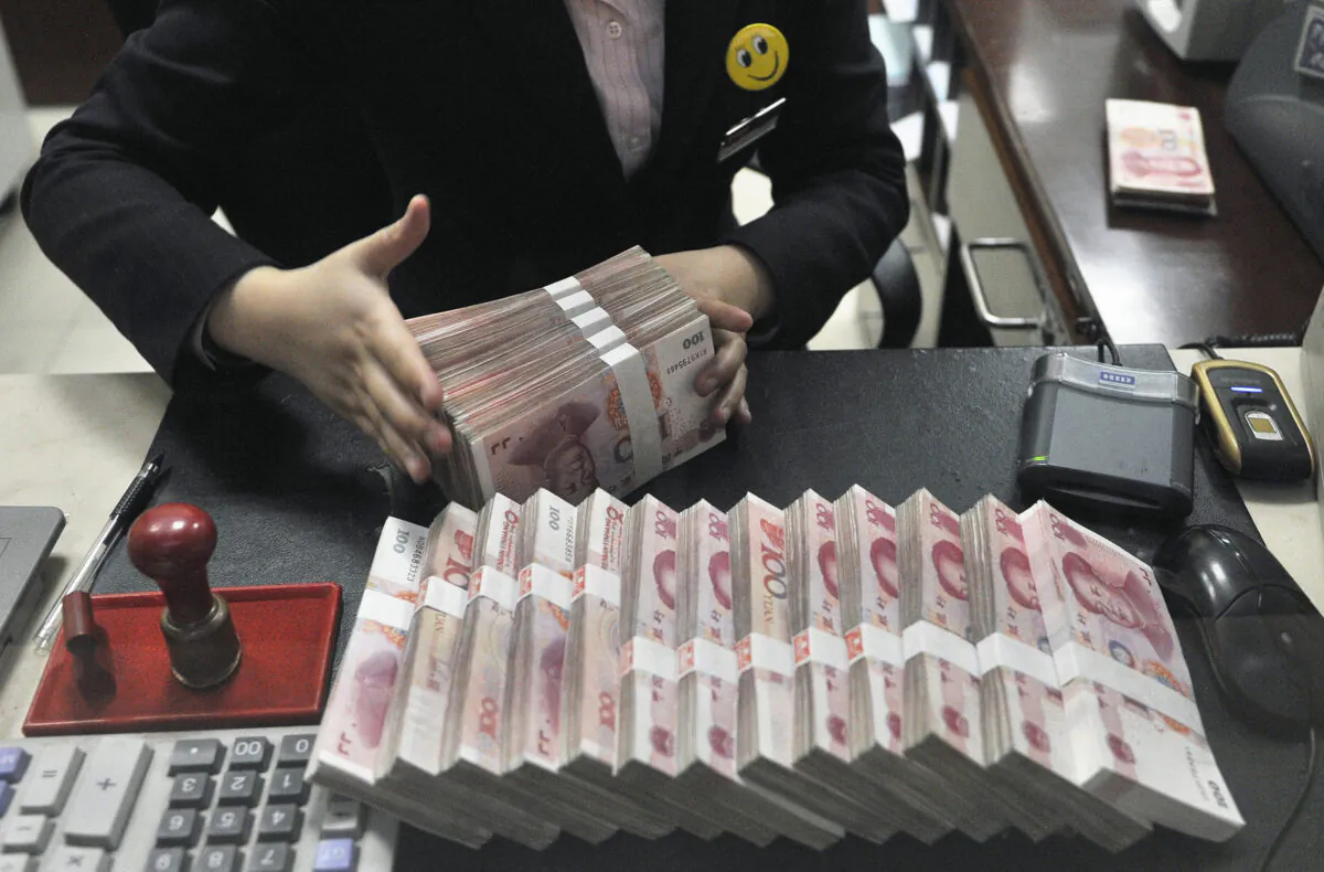 A clerk arranges bundles of 100 Chinese yuan banknotes at a branch of China Merchants Bank in Hefei, Anhui Province. (Reuters)