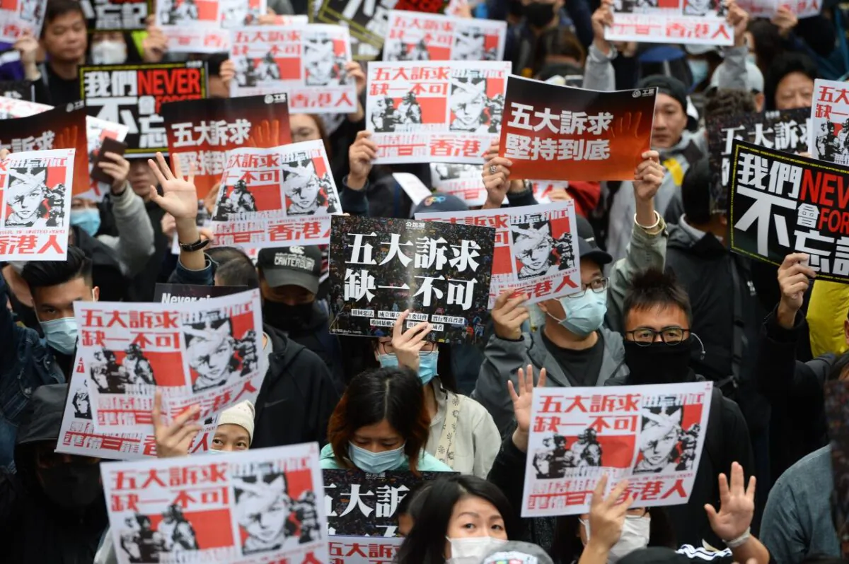 Protesters hold up placards with the words “Five Demands, Not One Less” in a march in Hong Kong on Jan. 1, 2020. (Sung Pi-lung/The Epoch Times)
