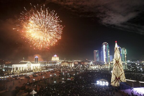 Fireworks explode over a Christmas tree