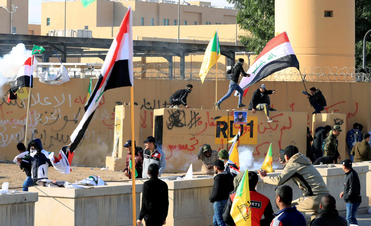 U.S. Embassy security forces use stun grenades to disperse protesters and militia fighters during a protest to condemn air strikes on bases belonging to Hashd al-Shaabi (paramilitary forces), outside the U.S. Embassy in Baghdad, Iraq on Jan. 1, 2020. (Thaier al-Sudani/Reuters)