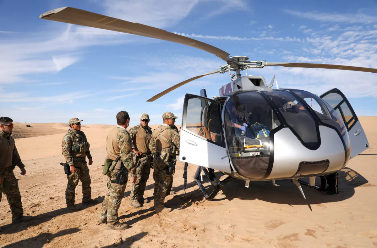 Border Patrol BORSTAR agents load an injured patient into a waiting helicopter in the Imperial Sand Dunes near the U.S.-Mexico border, Calif., on Nov. 30, 2019. (Charlotte Cuthbertson/The Epoch Times)
