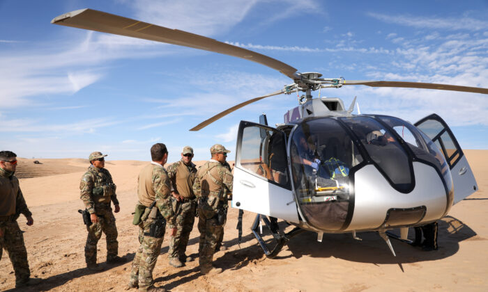 Border Patrol BORSTAR agents load an injured patient into a waiting helicopter in the Imperial Sand Dunes near the U.S.-Mexico border, Calif., on Nov. 30, 2019. (Charlotte Cuthbertson/The Epoch Times)