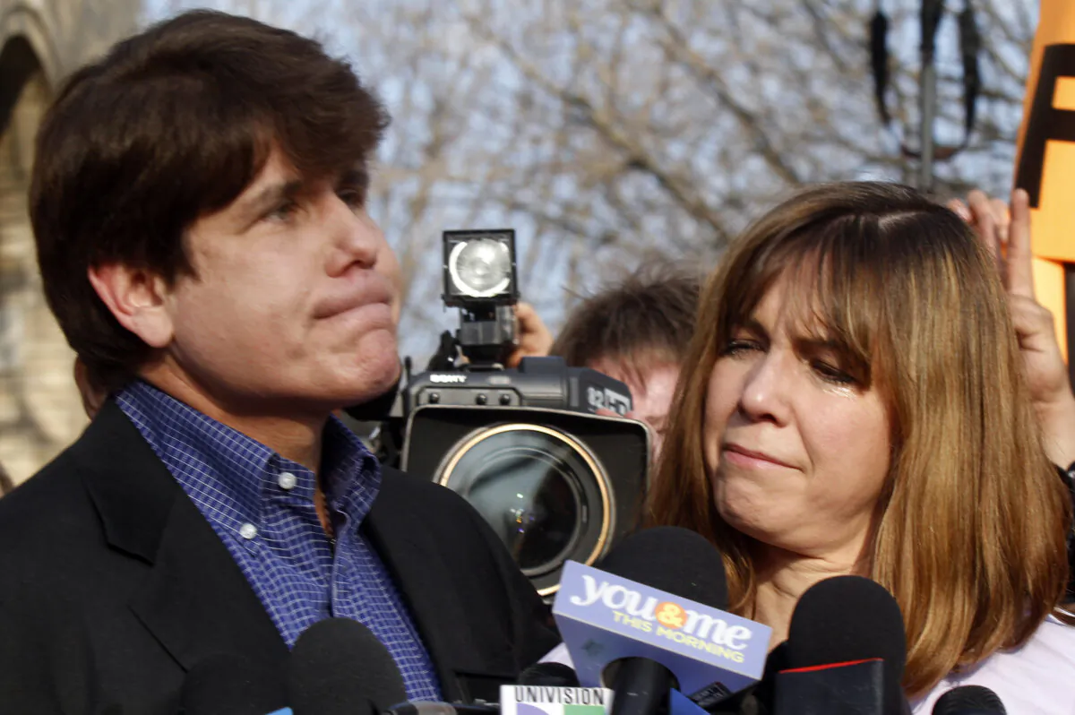 Patti Blagojevich (R), wife of disgraced former Illinois Governor Rod Blagojevich, looks at him while he pauses  at a news conference outside his home in Chicago on March 14, 2012. (Frank Polich/Getty Images)