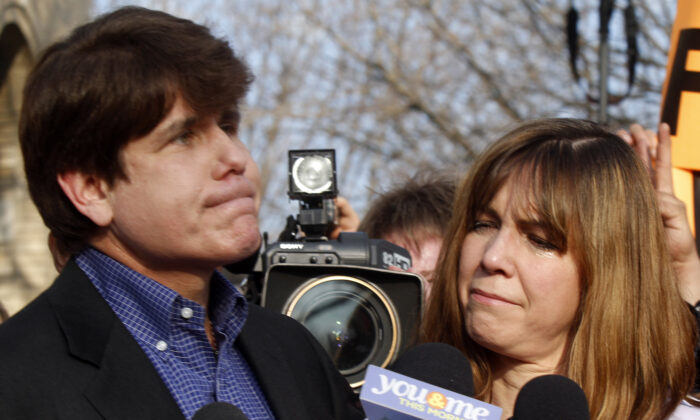 Patti Blagojevich (R), wife of disgraced former Illinois Governor Rod Blagojevich, looks at him while he pauses  at a news conference outside his home in Chicago on March 14, 2012. (Frank Polich/Getty Images)