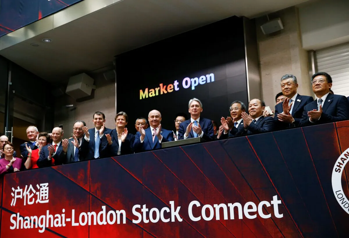 Britain's then-Chancellor of the Exchequer Philip Hammond (C) and Chinese Vice-Premier Hu Chunhua (C-R) applaud the launch of a stock link between the Shanghai and London stock exchanges, in London on June 17, 2019. Sources say listings were recently blocked by Beijing. (HENRY NICHOLLS/AFP via Getty Images)