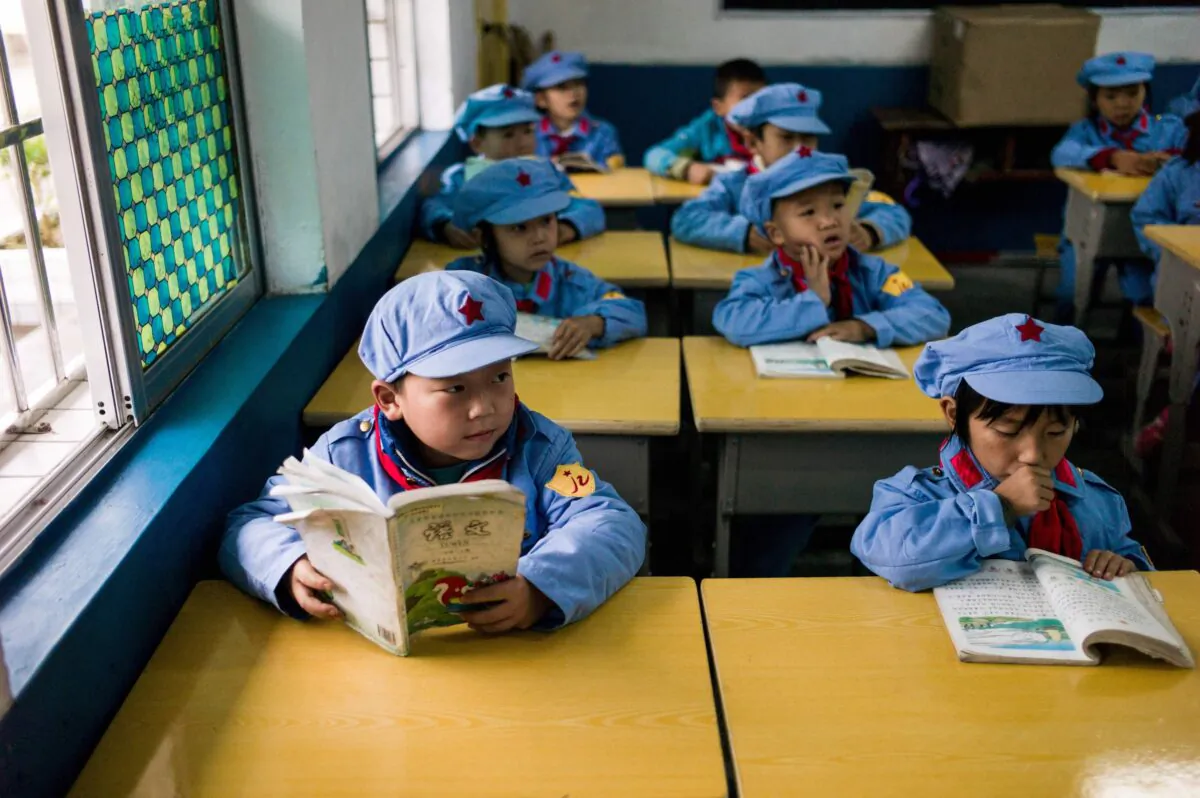 Students read in their classroom in the Yang Dezhi "Red Army" elementary school in Wenshui, Xishui County in Guizhou Province, China on Nov. 7, 2016. In 2008, Yang Dezhi was designated a "Red Army primary school"—funded by China's "red nobility" of revolution-era Communist commanders and their families, one of many such institutions that have been established across the country. Such schools are an extreme example of the "patriotic education" which China's ruling Communist party promotes to boost its legitimacy—but which critics condemn as little more than brainwashing. (Fred Dufour/AFP via Getty Images)