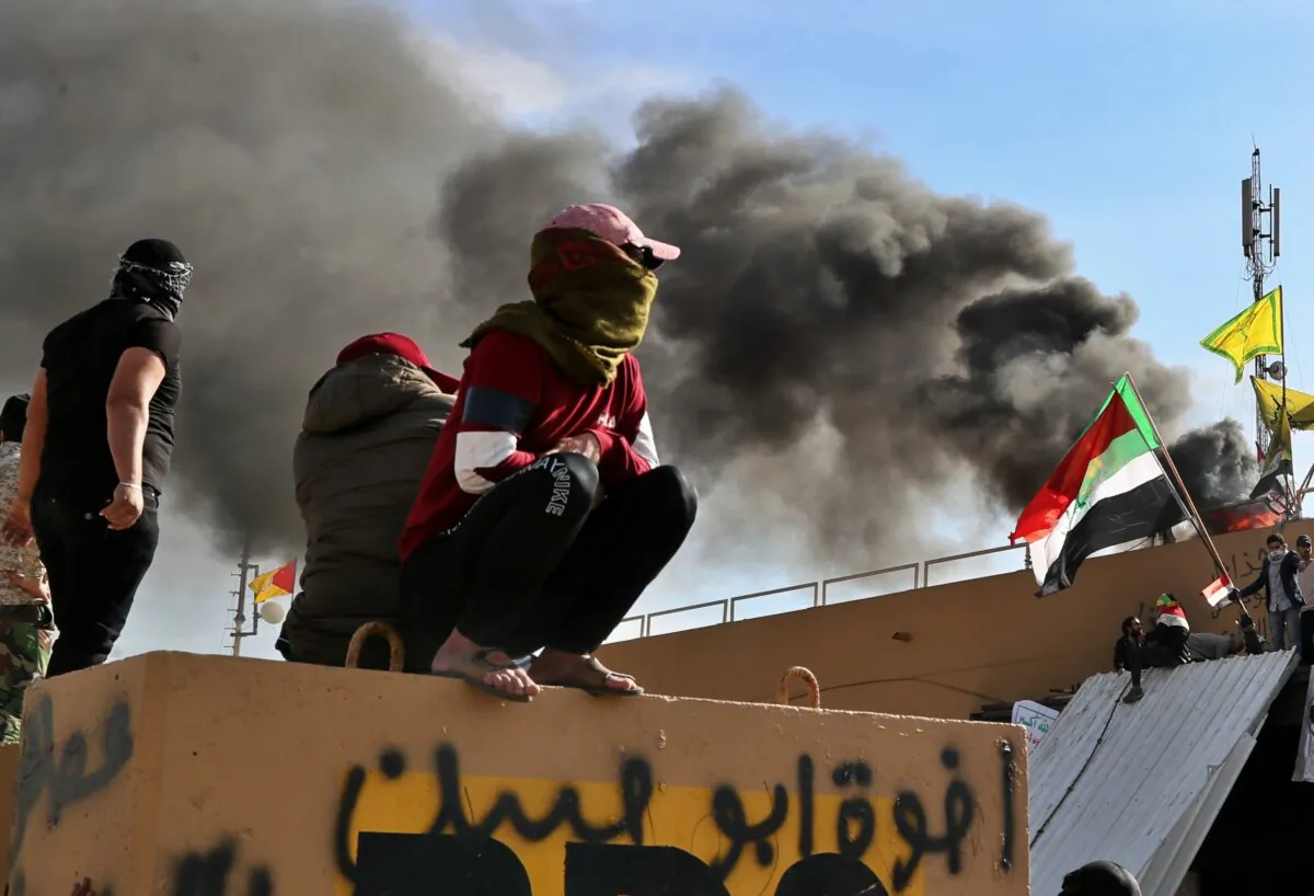 Pro-Iranian militiamen and their supporters set a fire during a demonstration in front of the U.S. embassy in Baghdad, Iraq, on Jan. 1, 2020. (Khalid Mohammed/AP Photo)