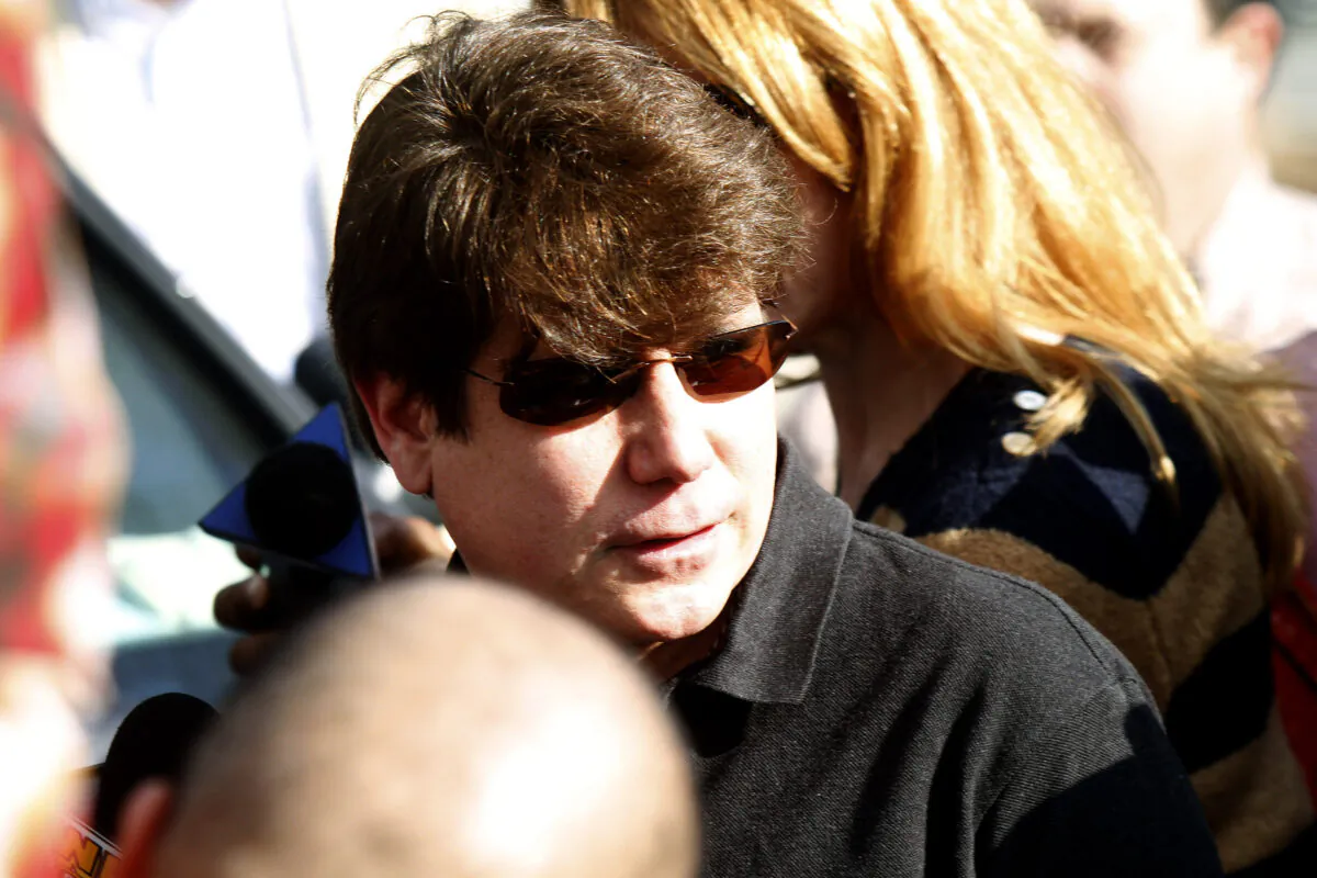 Convicted former Illinois Governor Rod Blagojevich walks through a horde of media toward his house before giving a news conference outside his home in Chicago on March 14, 2012. (Frank Polich/Getty Images)