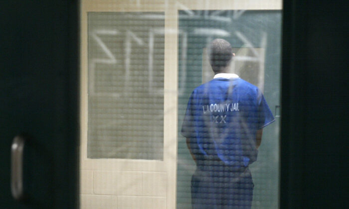 A prisoner waits in a holding cell in the Twin Towers Correction Facility during a media tour of the facility and the adjacent Los Angeles Men's Central Jail in downtown Los Angeles on May 19, 2004.   (Robyn Beck/AFP via Getty Images)