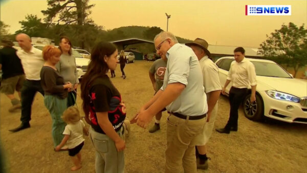 Australia's Prime Minister Scott Morrison attempts to shake a resident's hand