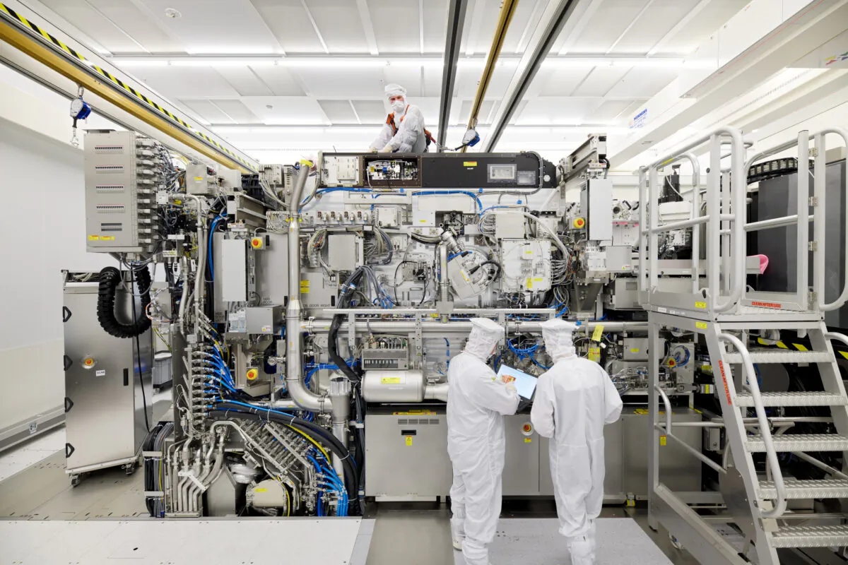 Employees work on the final assembly of ASML's semiconductor lithography tool with its panels removed, in Veldhoven, Netherlands, on April 4, 2019. (Bart van Overbeeke Fotografie/ASML/Reuters)