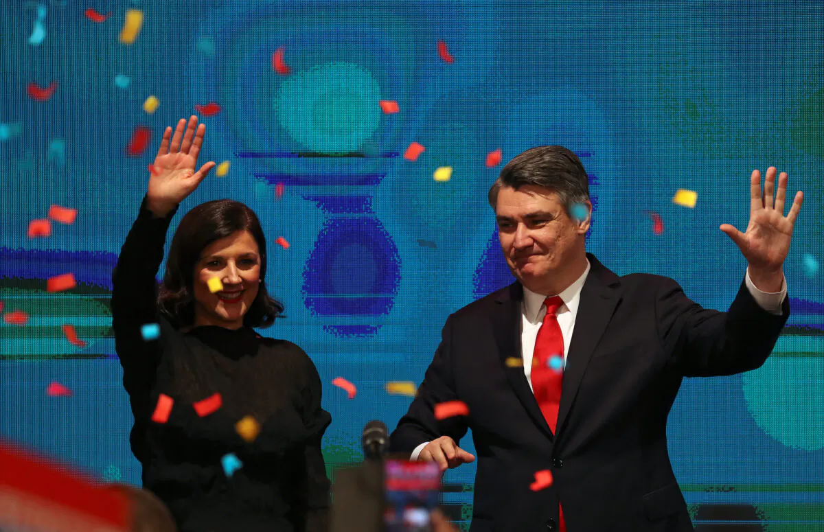 Zoran Milanovic waves next to his wife after first results were announced during the run-off of Croatia's presidential election in Zagreb, Croatia on Jan. 5, 2020. (Marko Djurica/Reuters)