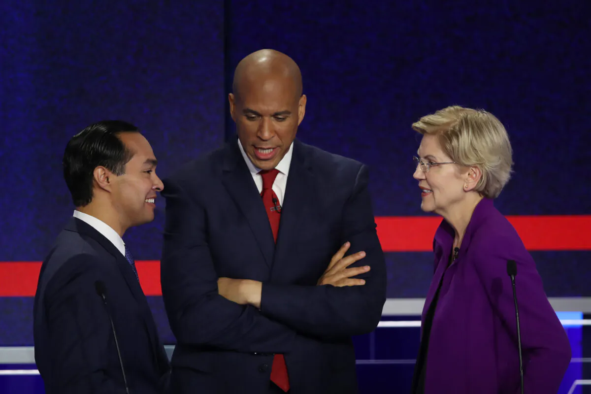 (L-R) Former housing secretary Julian Castro, Sen. Cory Booker (D-N.J.), and Sen. Elizabeth Warren (D-Mass.) talk during the first night of the Democratic presidential debate in Miami, Florida, on June 26, 2019. (Joe Raedle/Getty Images)