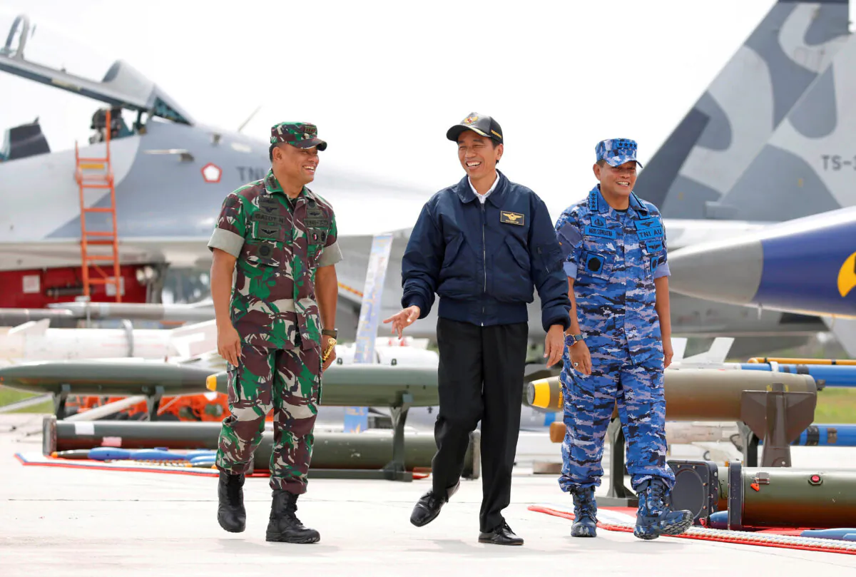Indonesia's President Joko Widodo (C) along with Military Chief Gatot Nurmantyo (L) and Air Force Commander Agus Supriatna walk past fighter jets and weapons during a military exercise on Natuna Island, Riau Islands province, Indonesia on Oct. 6, 2016. (Beawiharta/Reuters)
