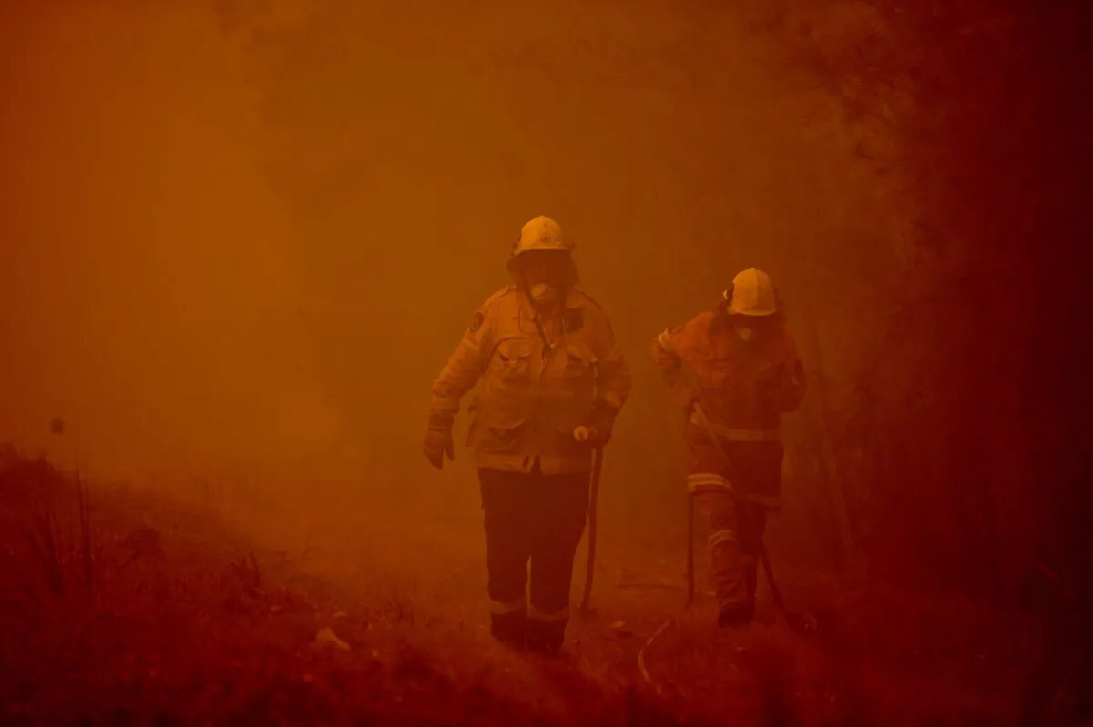 Firefighters tackle a bushfire in thick smoke in the town of Moruya, south of Batemans Bay, in New South Wales, Australia, on Jan. 4, 2020. (Peter Parks/AFP via Getty Images)