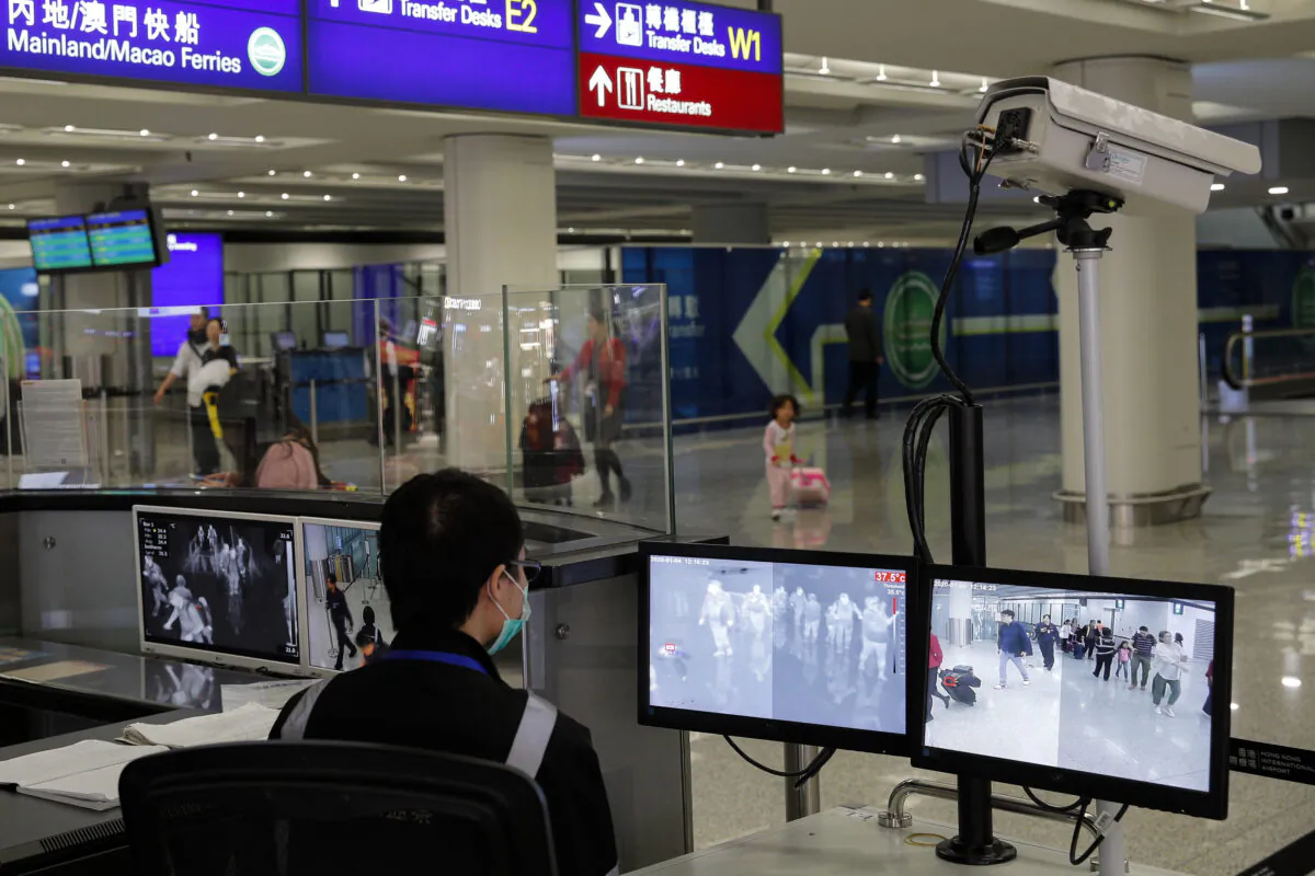 A health surveillance officer monitors passengers arriving at the Hong Kong International Airport in Hong Kong on Jan. 4, 2020. (AP Photo/Andy Wong)
