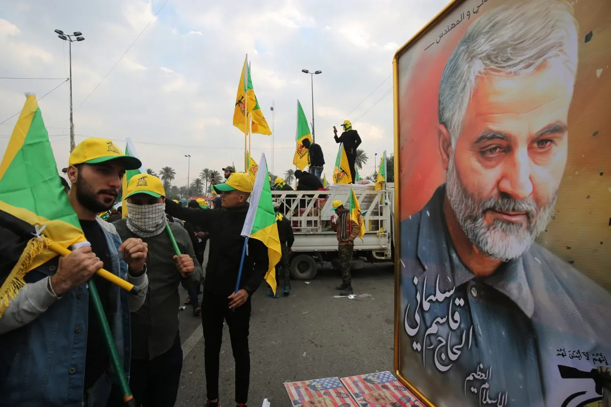 Supporters of the Hashed al-Shaabi paramilitary force and Iraq's Hezbollah brigades gather next to a poster of Iranian military commander Qasem Soleimani in Baghdad, Iraq, on Jan. 4, 2020. (Ahmad Al-Rubaye/AFP via Getty Images)