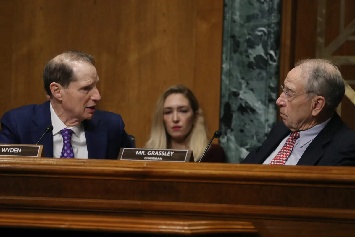 Sen. Ron Wyden (D-Ore.), left, talks with Chairman Chuck Grassley (R-Iowa) during a Senate Finance Committee committee hearing on Capitol Hill in Washington in a 2019 file photograph. (Mark Wilson/Getty Images)