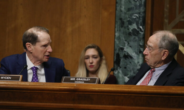 Sen. Ron Wyden (D-Ore.) (L) talks with Chairman Chuck Grassley (R-Iowa) during a Senate Finance Committee committee hearing on Capitol Hill in Washington in a 2019 file photograph. (Mark Wilson/Getty Images)