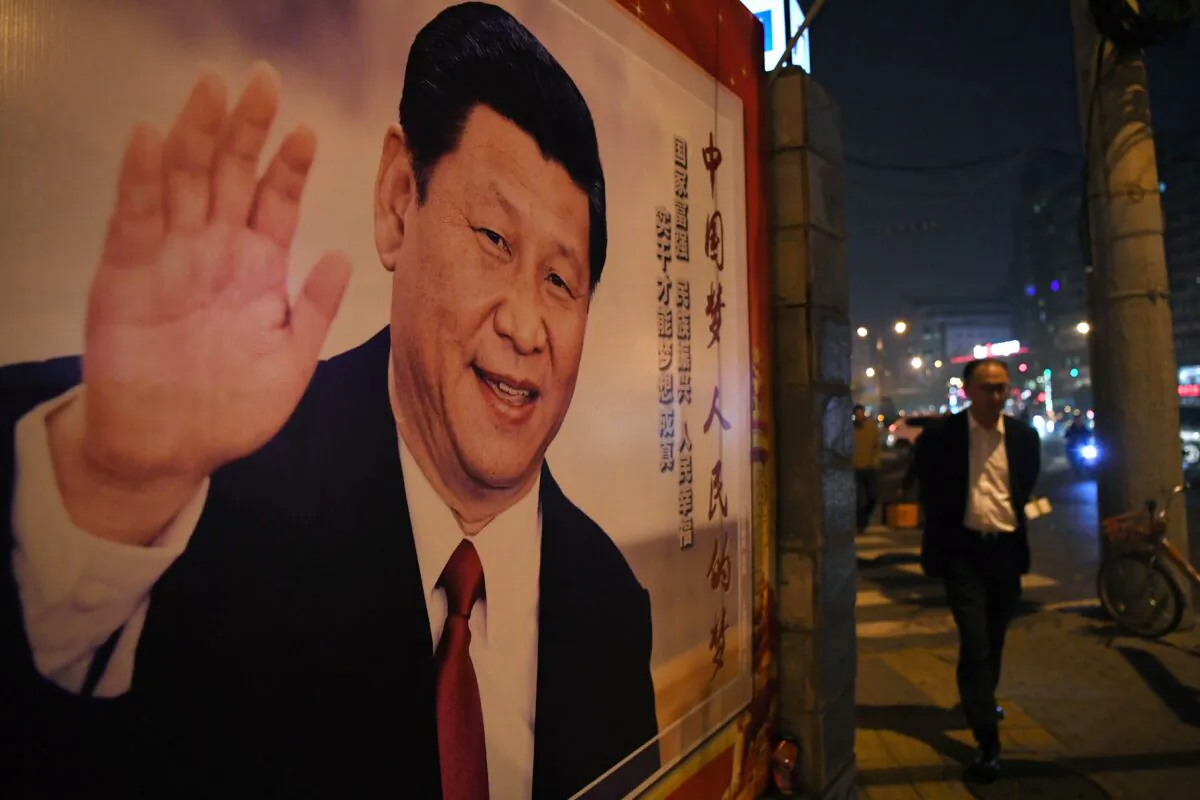 A man walks past a roadside poster of Chinese leader Xi Jinping after the closing of the 19th Communist Party Congress in Beijing on Oct. 24, 2017. (GREG BAKER/AFP via Getty Images)