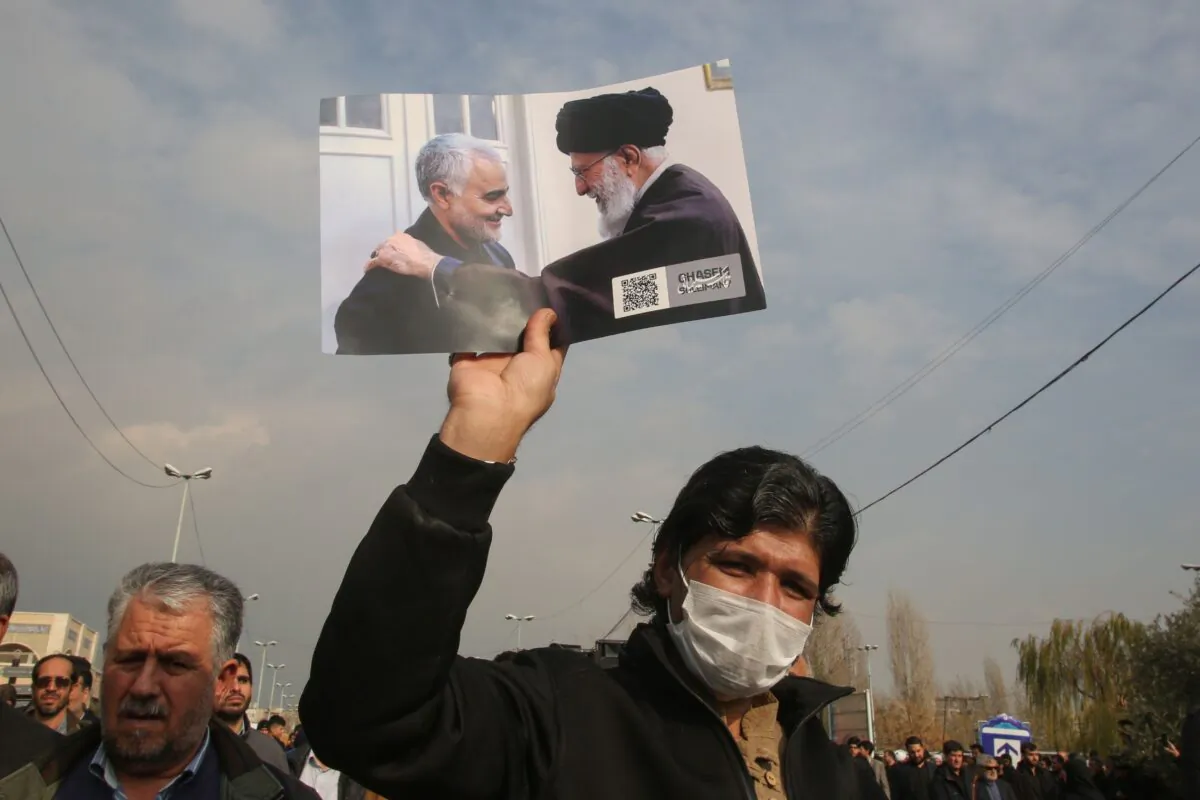 A man holds a picture of Iran's supreme leader Ayatollah Ali Khamenei with Iranian Revolutionary Guards Major General Qassem Soleimani (L) during a demonstration in Tehran on Jan. 3, 2020.  Atta Kenare/AFP via Getty Images